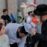 An ultra-Orthodox Jew swings a chicken over the head of a member of their family as they perform the Kapparot ceremony in an ultra-Orthodox neighbourhood in Jerusalem, on September 14, 2021. - Kapparot is a custom practised by some Jews, in which the sins of a person are symbolically transferred to a fowl, and is performed before Yom Kippur (Day of Atonement), the most important day in the Jewish calendar, which will start this year at sunset on September 15. (Photo by AHMAD GHARABLI / AFP) (Photo by AHMAD GHARABLI/AFP via Getty Images)