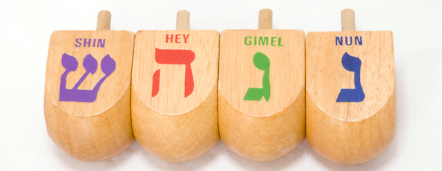 PHOTO: Four dreidels showing each of the four sides are shown. The four letters on dreidels are nun, gimel, hey and shin. 