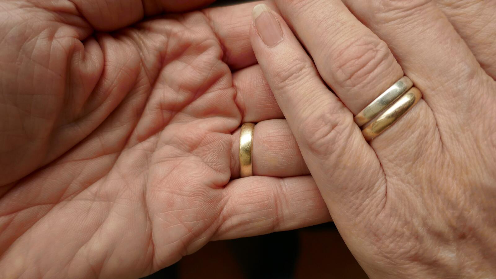 close up of hands with wedding rings