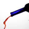 blue bottle pouring red wine against a whitebackground