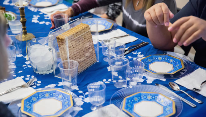 A traditional Passover seder table, featuring matzah, glasses of wine, and other traditional Passover foods.