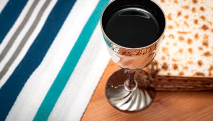 A Kiddush cup filled with wine next to matzah, the unleavened bread that is traditionally eaten during the Jewish holiday of Passover