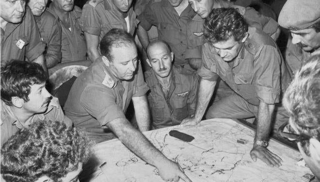 black and white photo of soldiers consulting a map