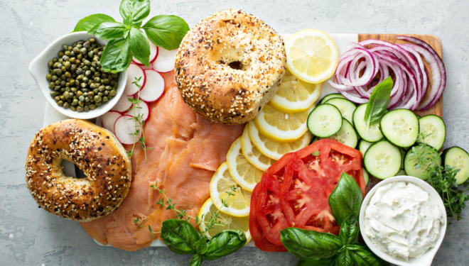 Bagel board with salmon, capers, cream cheese, lemons, vegetables