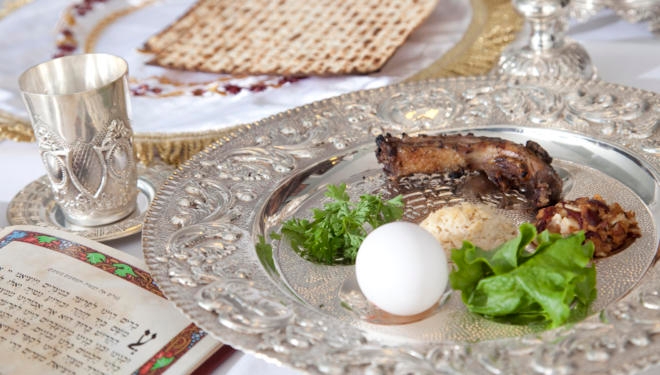 Elements of a traditional Passover seder, including a seder plate, a Kiddush cup for wine, and matzah. The seder plate includes symbolic foods that are related to the Exodus.