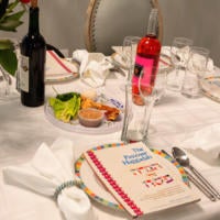 A traditional Passover seder table, featuring a Haggadah, a seder plate, wine and some of the foods enjoyed during the Jewish holiday of Passover