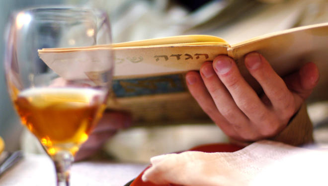 At a Passover seder, a participant reads from a Haggadah, the book used during the seder to retell the story of Exodus.