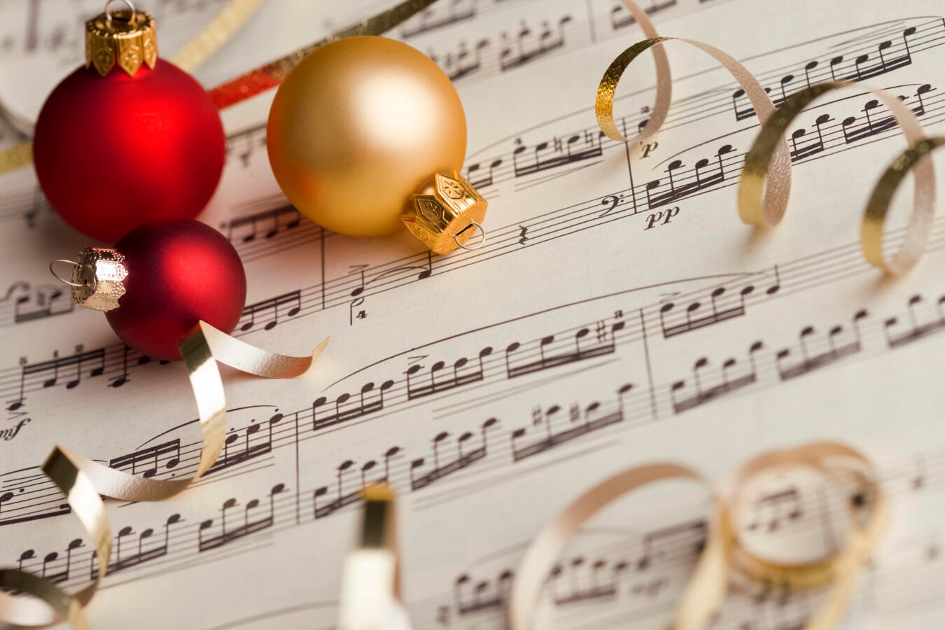 christmas ornaments lying on top of sheet music