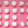 white marshmallows on a pink background.