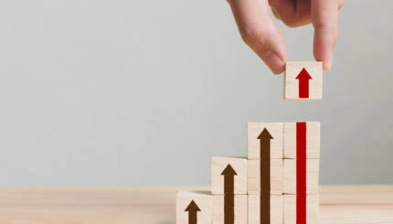 Hand arranging wood block stacking as step stair with arrow up. Ladder career path concept for business growth success process