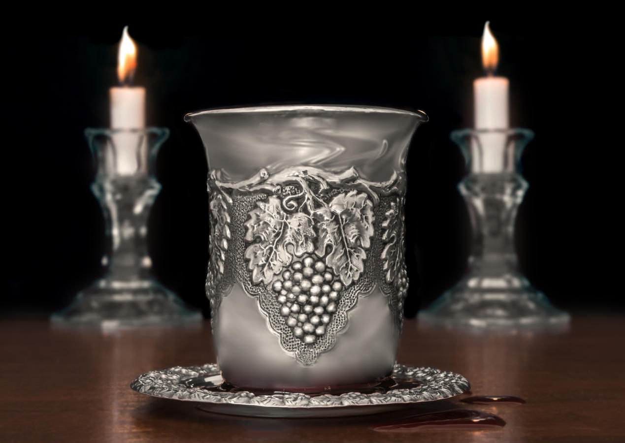 Jewish Sabbath traditional silver kiddush cup on wood texture