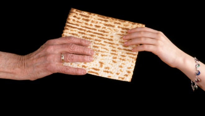 Handing a matzo from an old hand to a young hand.
