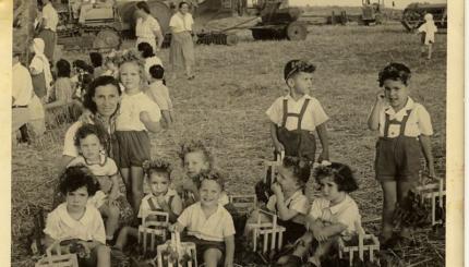 B&w photo of children in a field with flowers in their hair.