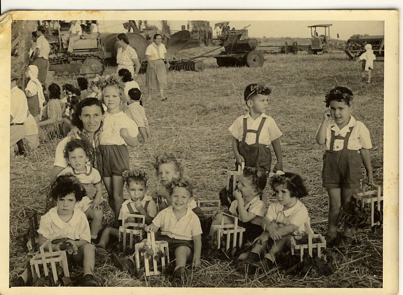 B&w photo of children in a field with flowers in their hair.