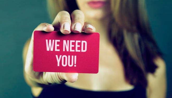 Young woman holding we need you card