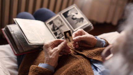 Senior adult woman looking at an old photo of her husband.