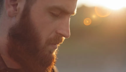 young bearded man with eyes closed