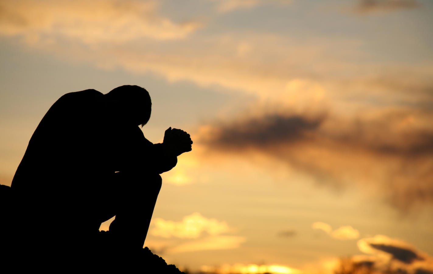 Silhouette of Unrecognizable Man Praying Outside