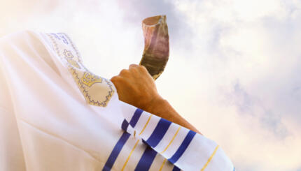 Jewish man blowing the Shofar (horn) of Rosh Hashanah (New Year). Religious symbol