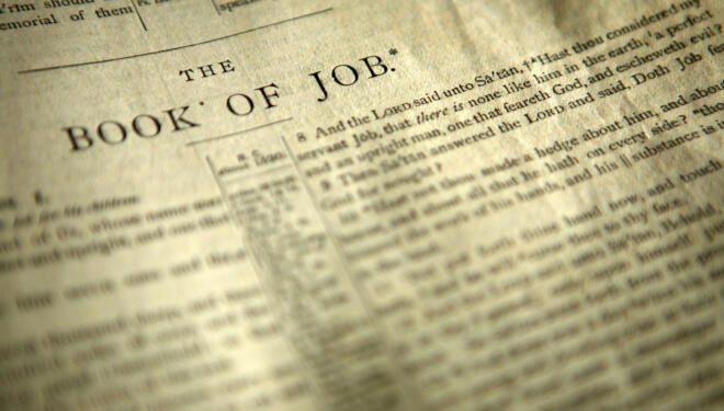 Bible open to the first page of the Book of Job.