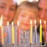 picture of family lighting hanukkah candles