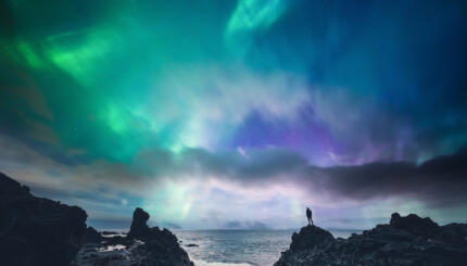 Silhouette of a man contemplating the northern lights.