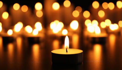 Burning candle on black table.