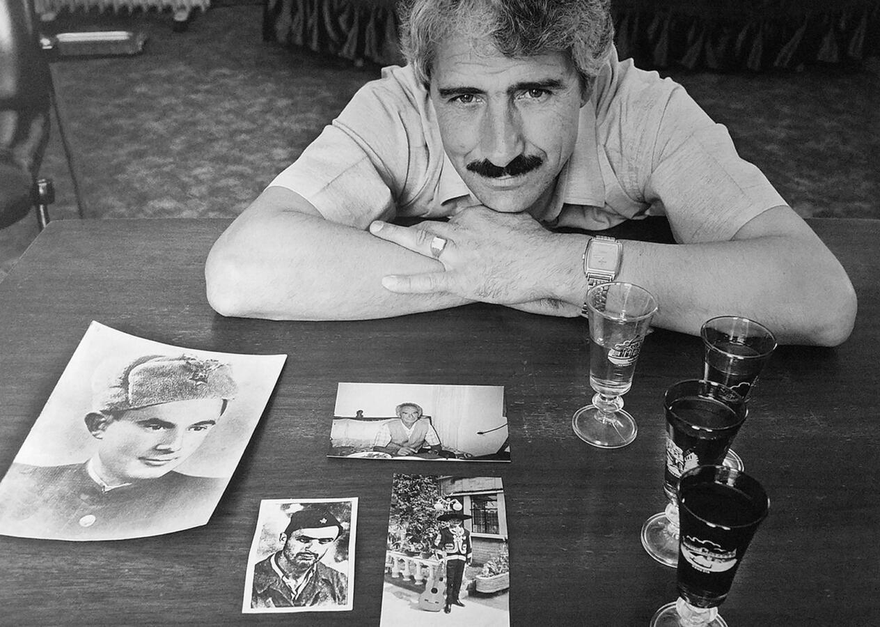 Photograph taken by Norman Gershman for BESA. This photograph is of Enver Alia Sheqer with family photos. His father was Ali Sheqer Pashkaj, one of the Albanian Muslims who rescued Jews during WWII.