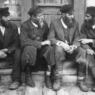 Krasilov, Ukraine (Russian / Polish shtetl or Jewish village ).c. 1916-17. Jewish men sitting outside shop talking