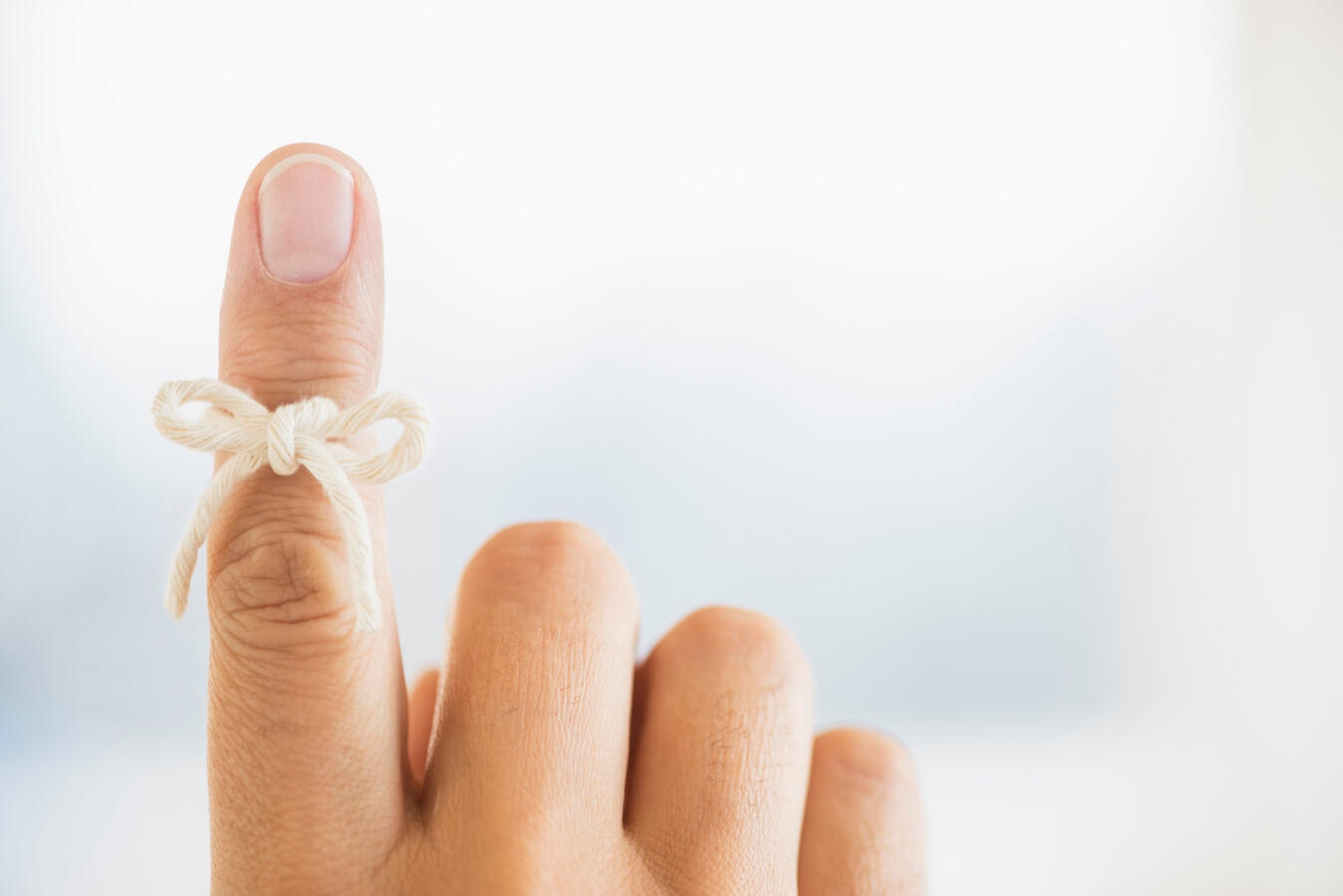 Hand with reminder bow on finger