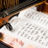 Photo of an open book of psalms and a violin.