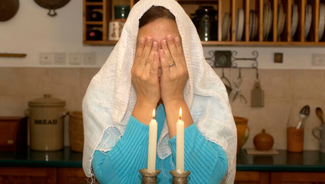 Jewish woman lighting shabbat candles.