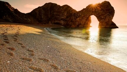 A beach with footsteps in the sand.