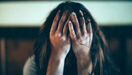 woman covering her face with her hands