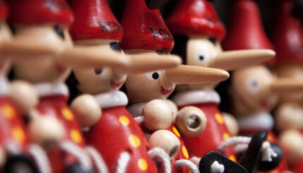 Photo of a row of Pinocchio dolls with long noses.