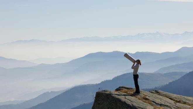 Woman on a mountain shouting through a megaphone.