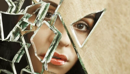 Close up of a woman looking through broken glass