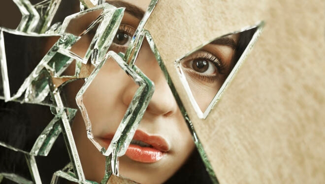 Close up of a woman looking through broken glass