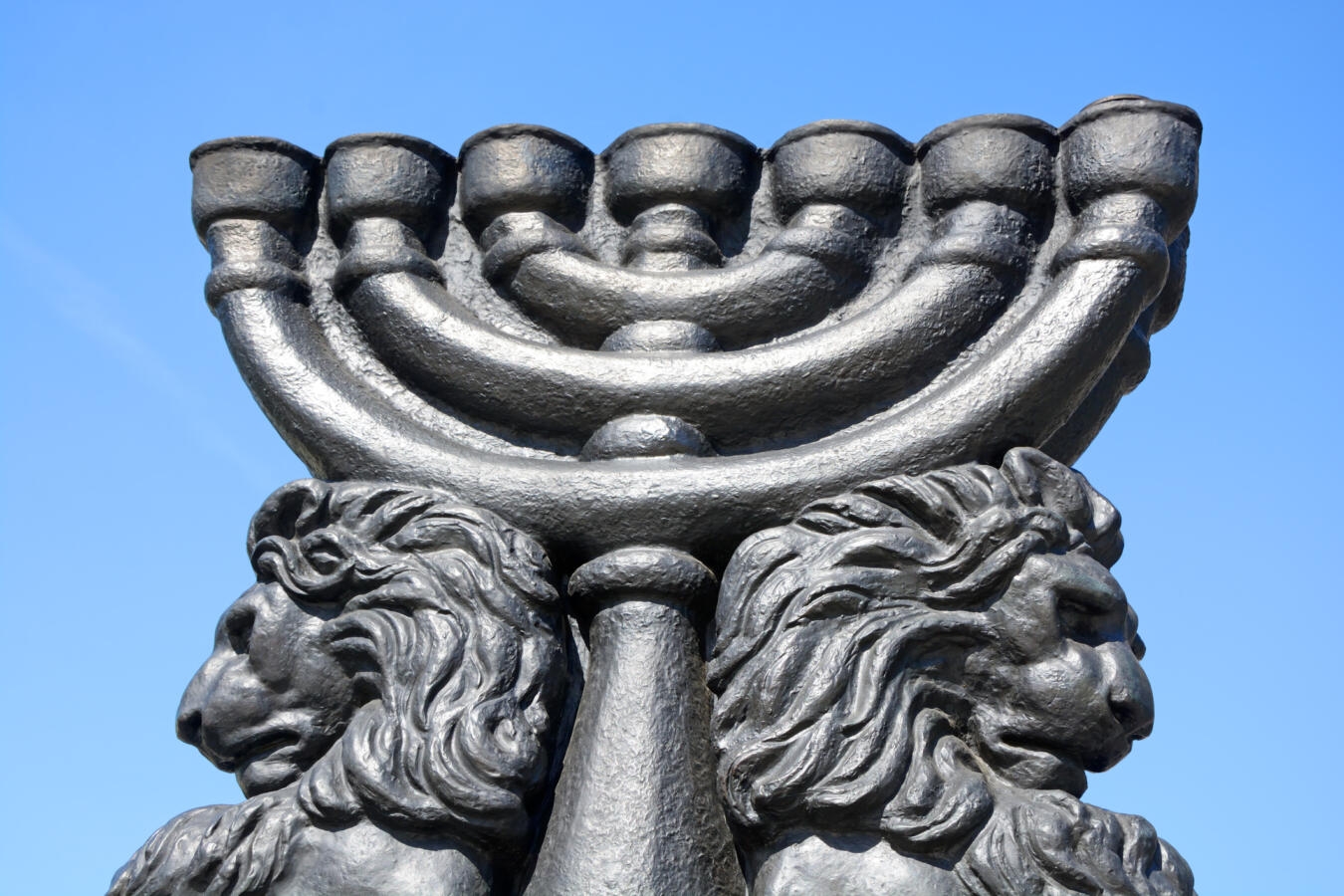 Image of an outdoor, seven-branched menorah flanked by lions.