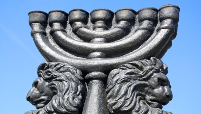 Image of an outdoor, seven-branched menorah flanked by lions.