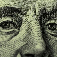 close up photo of benjamin franklin's eyes from the $100 bill