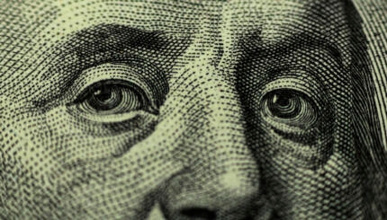 close up photo of benjamin franklin's eyes from the $100 bill