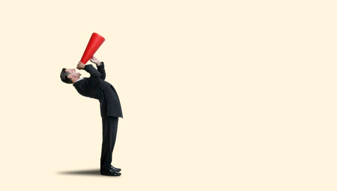 A businessman bends over backward as he shouts into a red megaphone isolated against a yellow background.