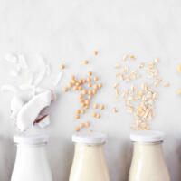 Vegan, plant based, non dairy milk. Above view in milk bottles with ingredients.