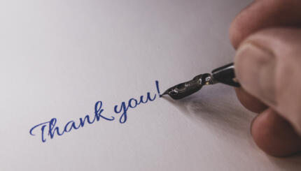 Close-up of a hand from a person writing thank you with a Fountain pen.