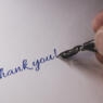 Close-up of a hand from a person writing thank you with a Fountain pen.