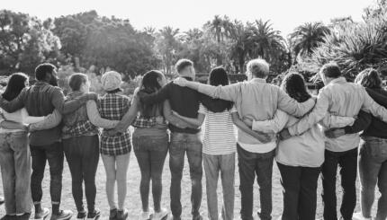 Group of multigenerational people hugging each others - Support, multiracial and diversity concept - Main focus on center people - Black and white editing