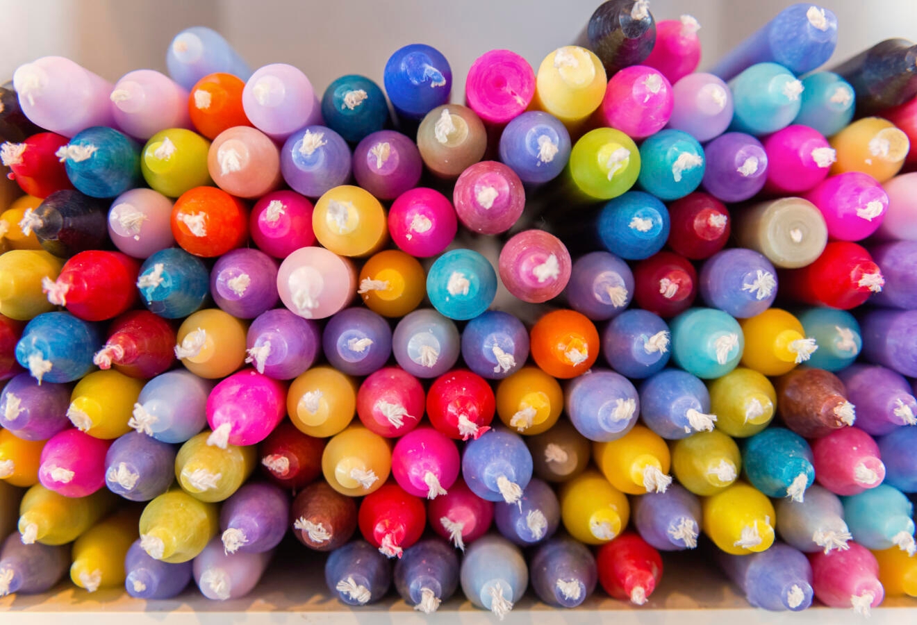 photograph of a bin of colorful candles
