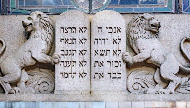 stone relief carving of the ten commandments flanked by two lions