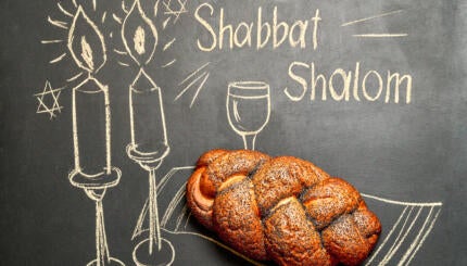 chalkboard that says "shabbat shalom" with challah